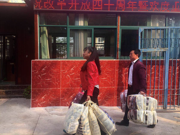 慰問團成員手拎慰問物品正大步走向惠康漢生老年公寓