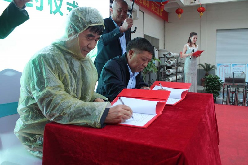 廣力總裁徐貴山與河北省唐山市潤豐印務有限公司董事長薄會川(穿雨衣者)在《購機協議書》上簽名